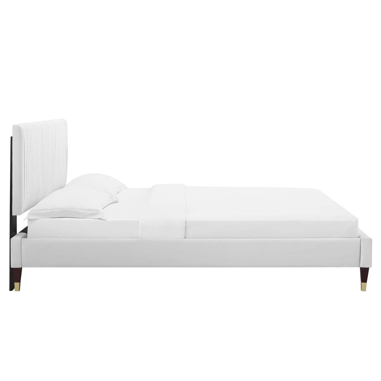 White velvet upholstered full platform bed with a tall padded headboard, white linens and gold-tipped legs.