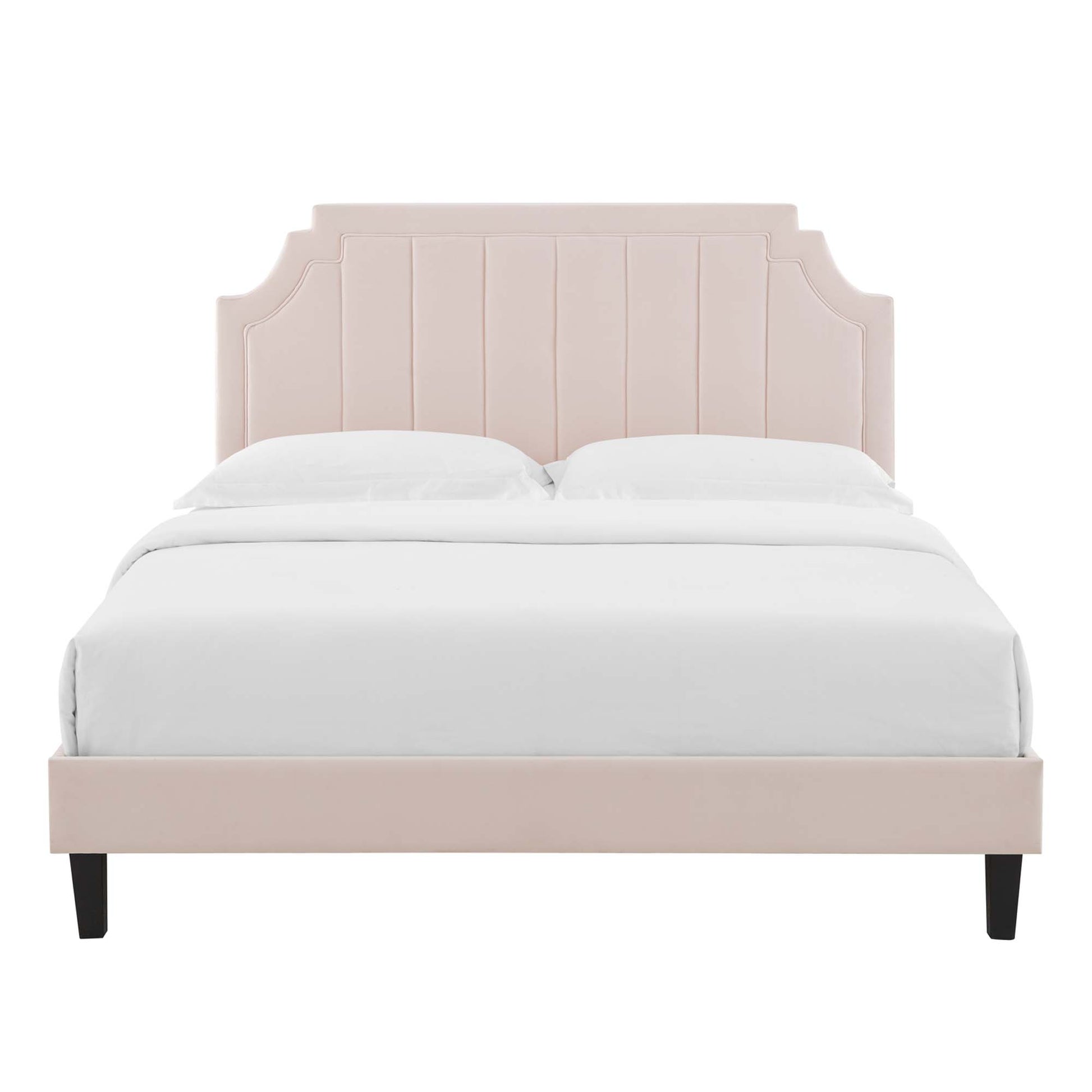 Blush pink upholstered bed with tall paneled headboard and black tapered legs, white bedding.