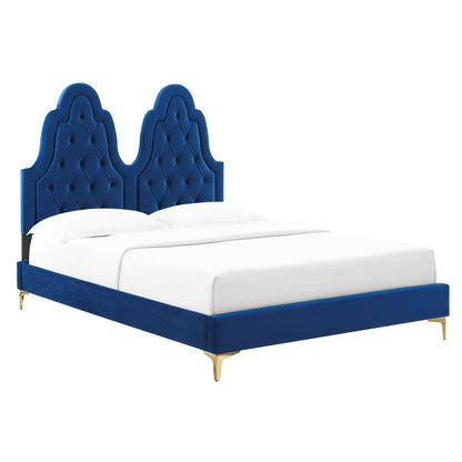 Navy blue velvet platform bed with double tufted arched headboard, gold legs, and white bedding.