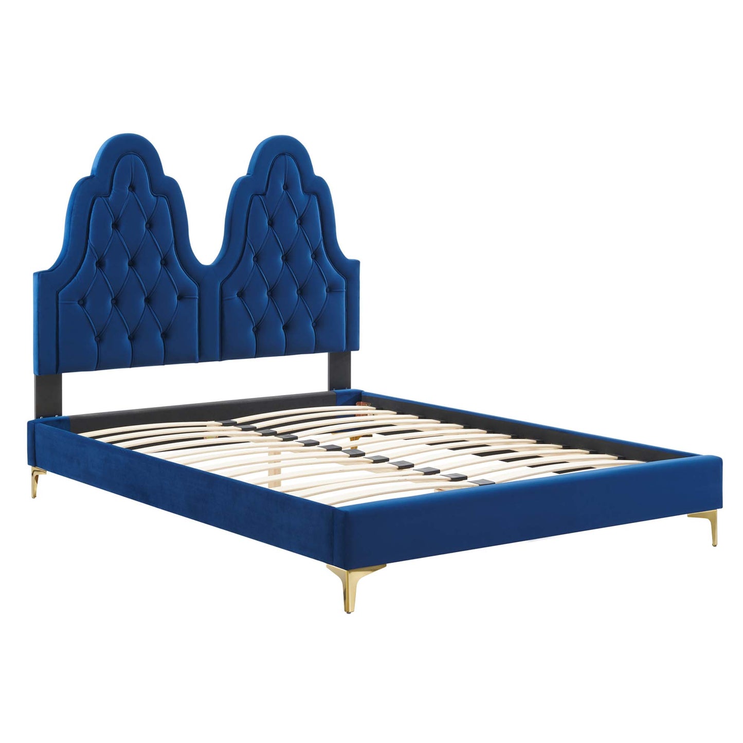 Navy blue velvet bed with double arched tufted headboard, low platform frame, gold tapered legs.
