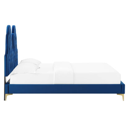 Navy velvet platform bed with tall tufted headboard, navy frame and gold legs, white bedding.