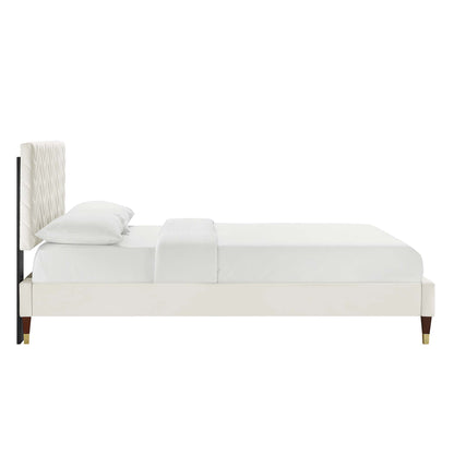 White upholstered platform bed with tall quilted headboard, cream fabric, slim gold-tipped legs, modern style.