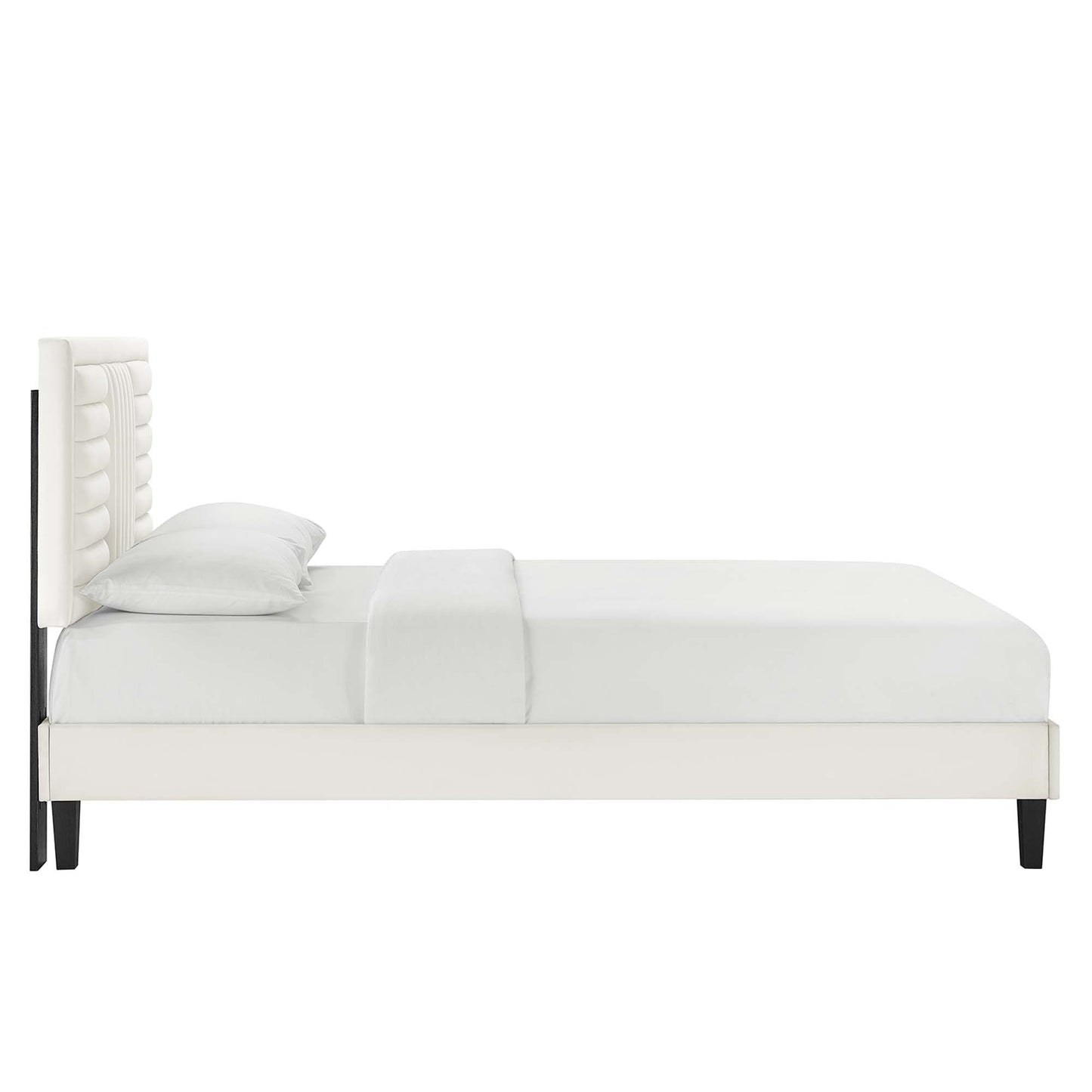 White upholstered platform bed with tufted headboard, minimalist design & black tapered legs.