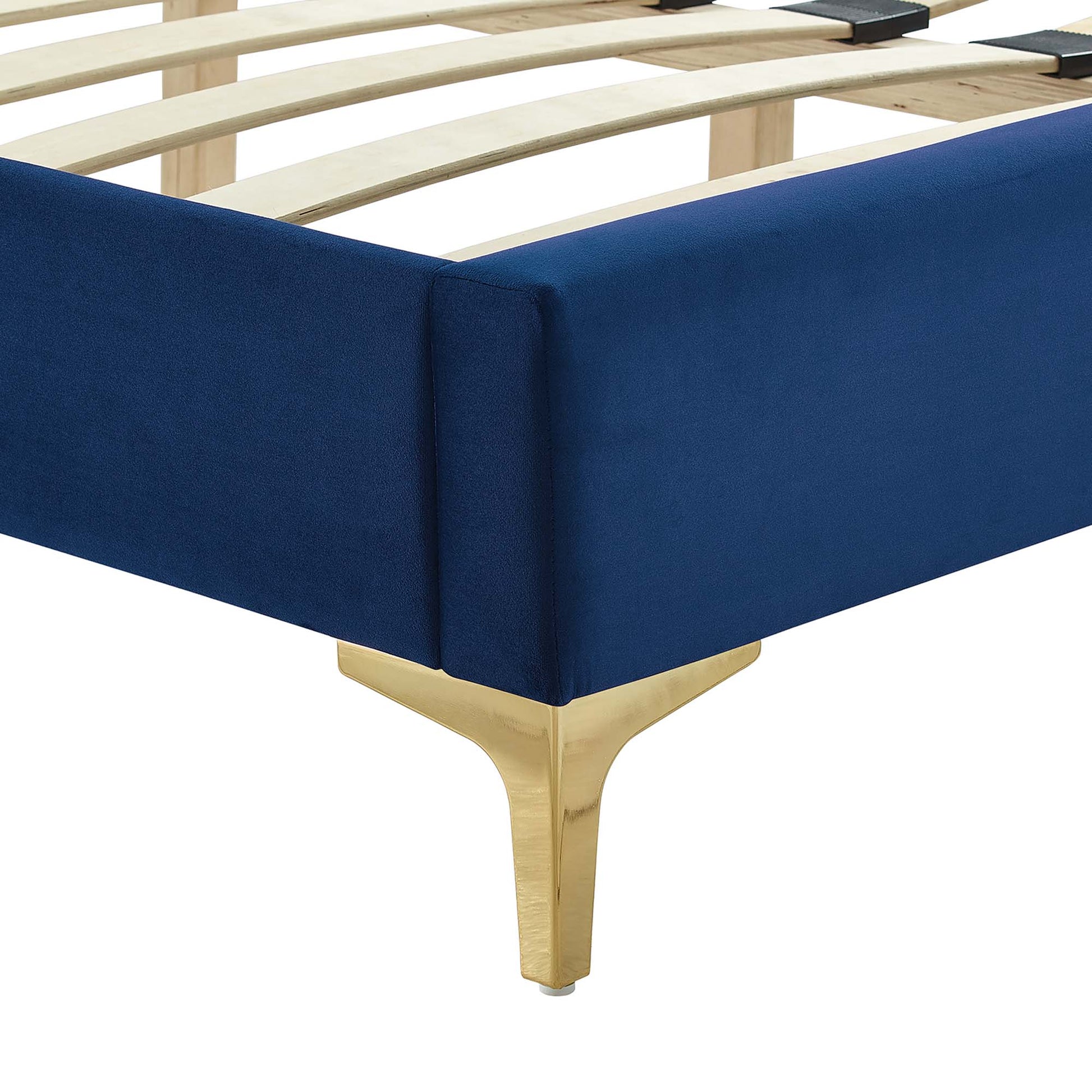 Navy upholstered platform bed with gold tapered legs and wooden slat support.