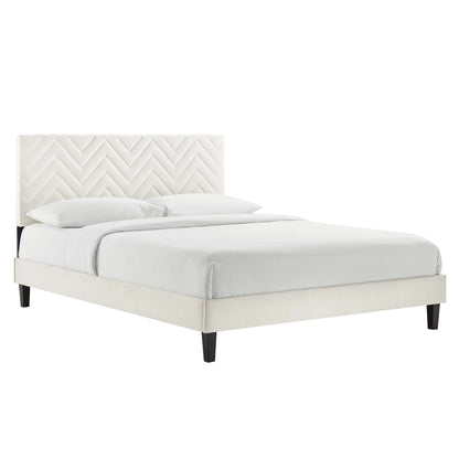 White upholstered twin platform bed with chevron tufted headboard, low platform frame, dark wood legs, white bedding.