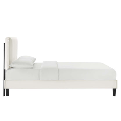 White upholstered platform bed with tall padded headboard, light bedding, and black tapered legs; modern minimalist style.