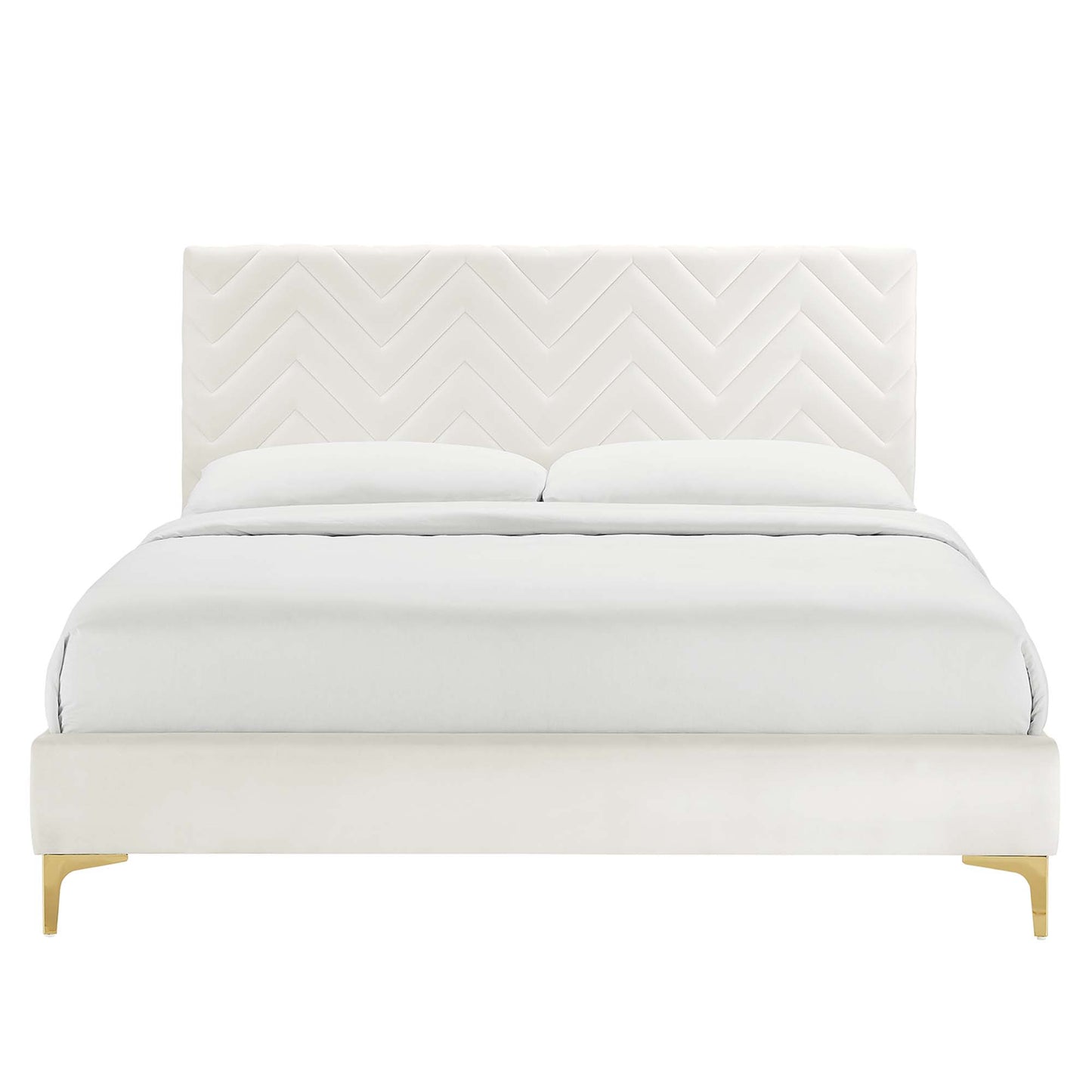 White upholstered full platform bed with chevron-tufted headboard, white bedding, and white platform with wooden legs.