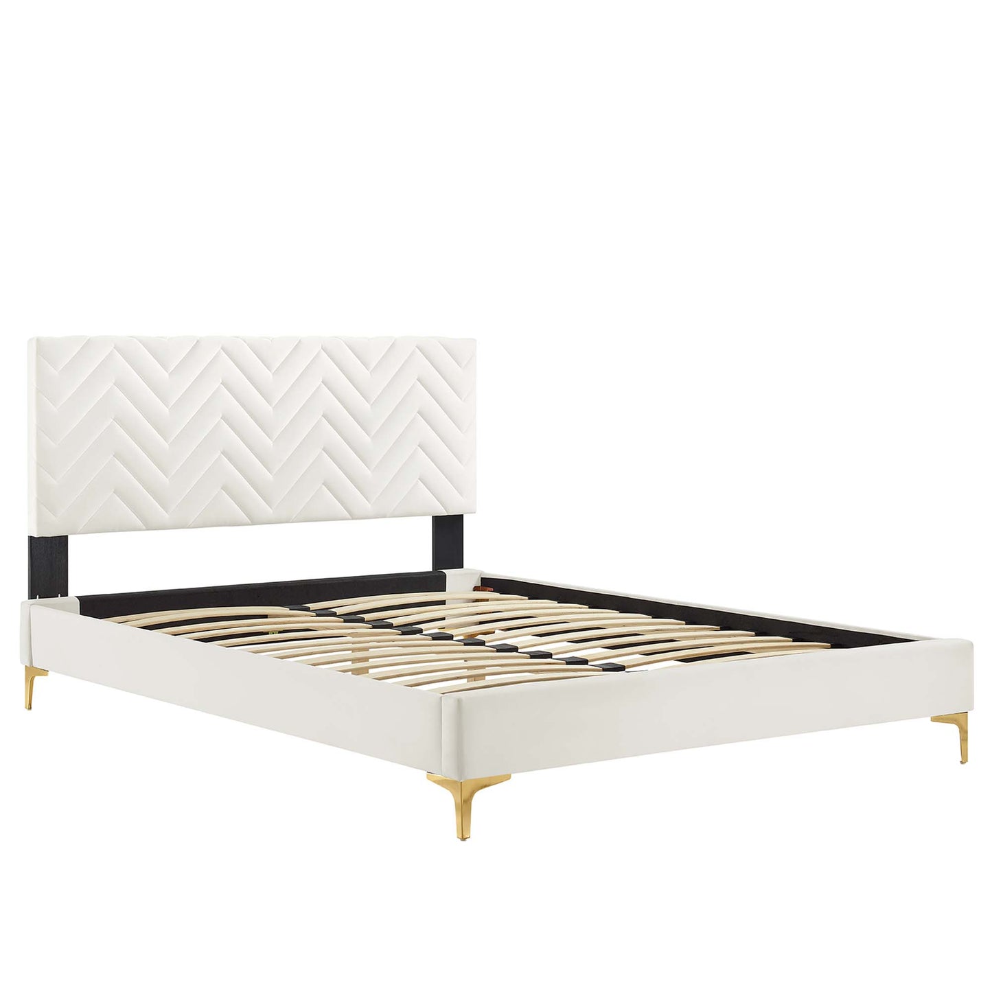 White upholstered platform bed with chevron-stitched headboard, black support bar, gold tapered legs, wooden slat base.