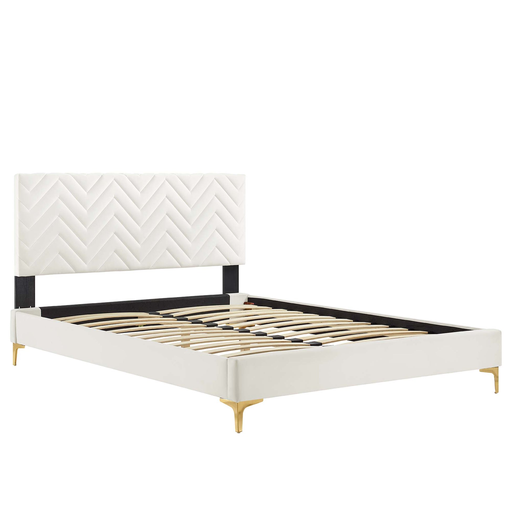 White upholstered platform bed with chevron-stitched headboard, black support bar, gold tapered legs, wooden slat base.