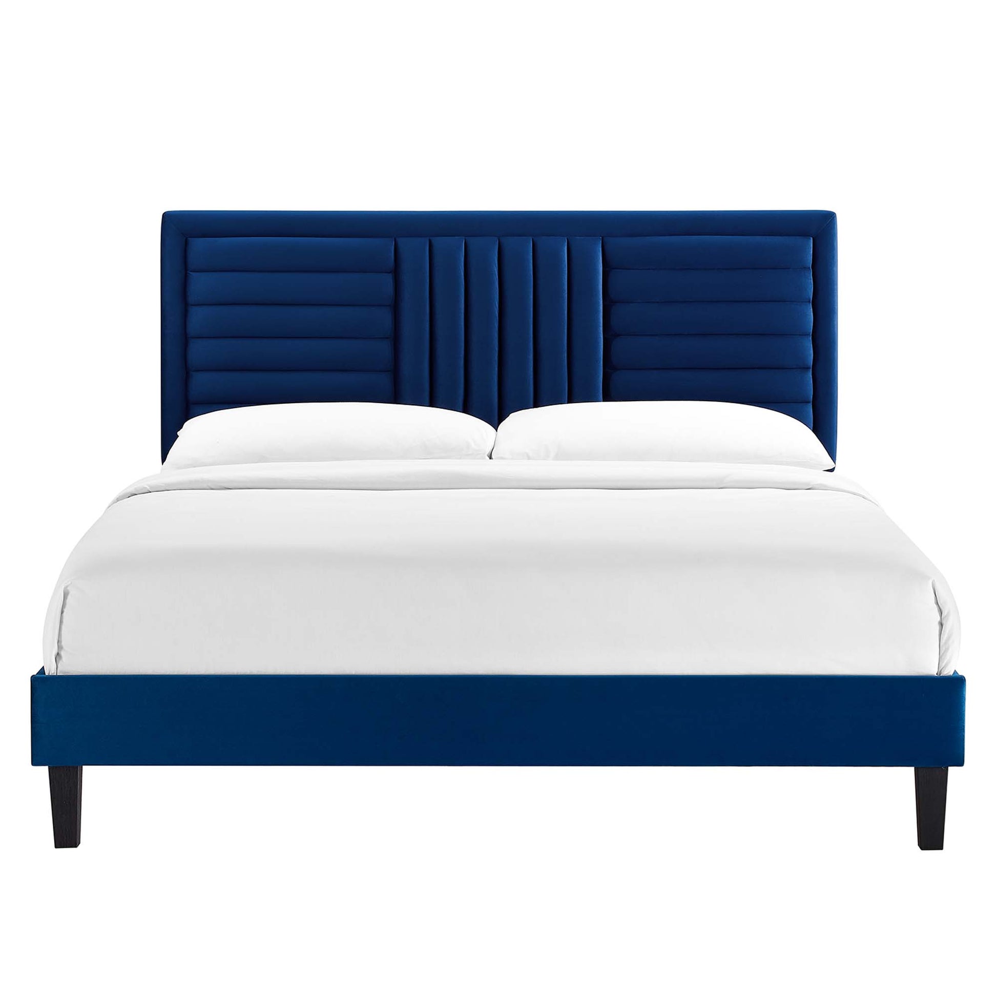 Navy blue upholstered platform bed with tall, channel-tufted headboard and white bedding; dark tapered legs.