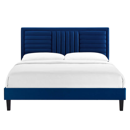 Navy blue upholstered platform bed with tall, channel-tufted headboard and white bedding; dark tapered legs.