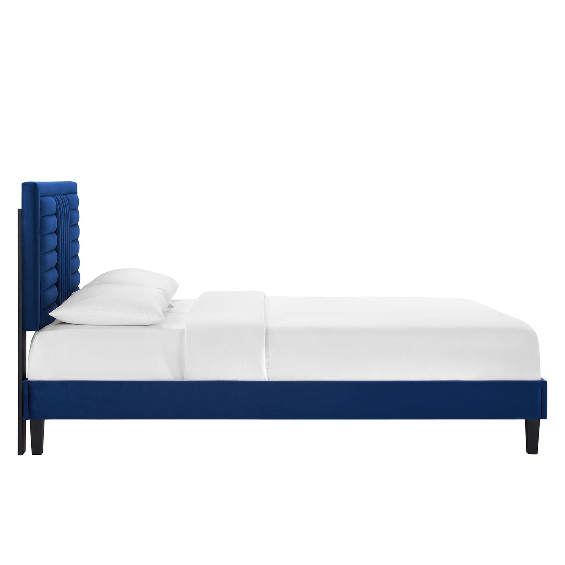 Navy blue platform bed with tall tufted headboard, white bedding, modern minimalist style, dark legs.