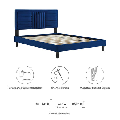Navy blue velvet upholstered platform bed with tall channel-tufted headboard, wood slat support & tapered legs.