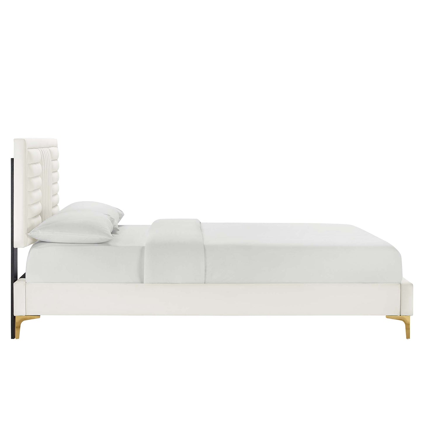 White upholstered platform bed with tall tufted headboard and white bedding, paired with light wood legs.