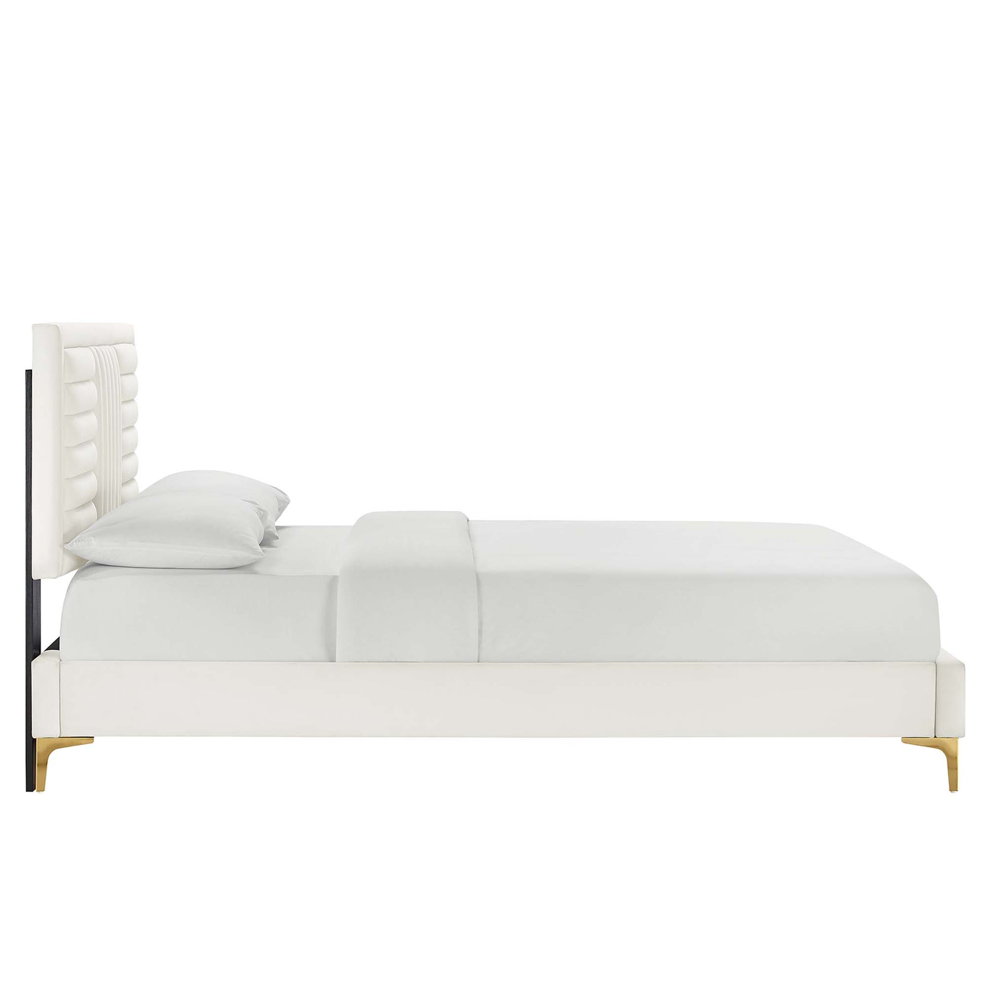 White upholstered platform bed with tall tufted headboard and white bedding, paired with light wood legs.