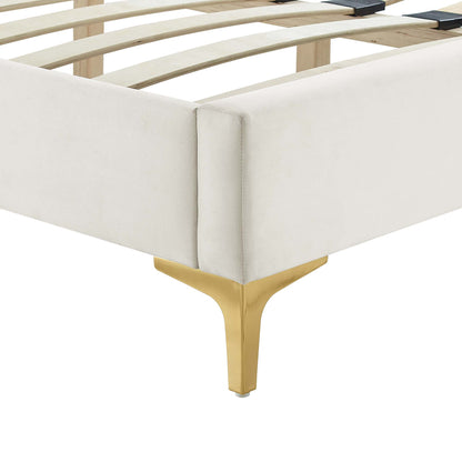 Cream upholstered platform bed frame with gold-tone metal leg and visible wooden slats.
