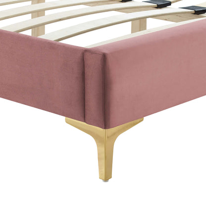 Blush pink velvet upholstered platform bed with gold curved Y-leg and wooden slat base.