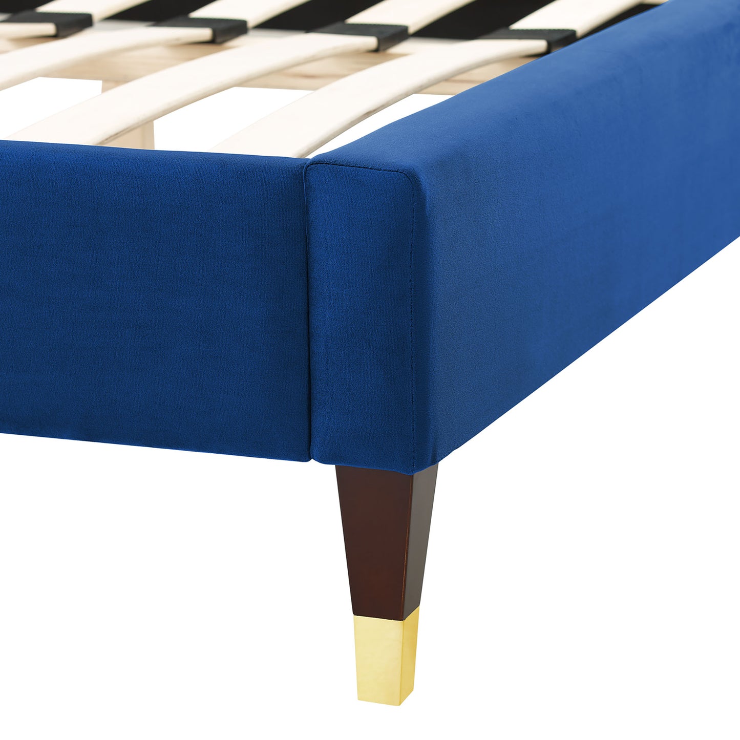 Navy velvet upholstered full bed with dark wood tapered legs and brass-cap feet; slatted base visible.