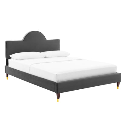 Dark gray upholstered platform bed with curved headboard, white bedding, and wooden legs with gold-toned tips.
