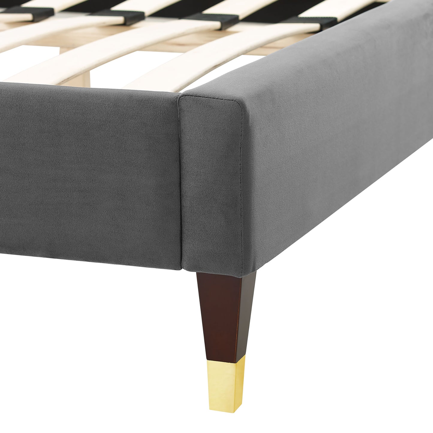 Gray fabric upholstered bed frame corner with slatted base, tapered wooden leg & brass foot cap.