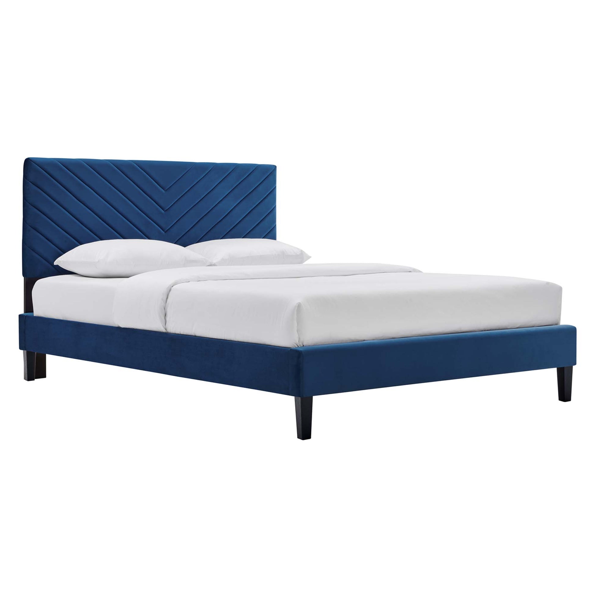 Navy blue upholstered platform bed with chevron-stitch headboard and white bedding, black tapered legs.