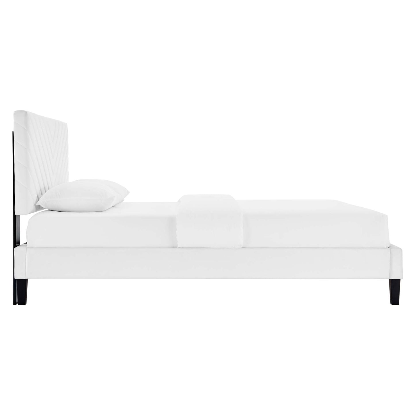 White upholstered king platform bed with tall padded headboard, white bedding, and dark tapered legs.