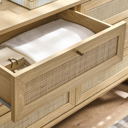 Oak dresser with woven cane fronts; open top drawer reveals a white towel and a small wrapped box.