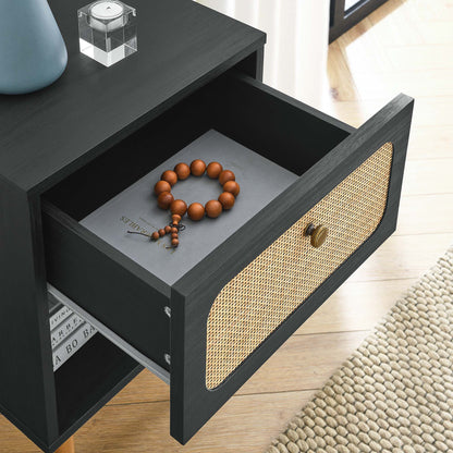 Black wooden nightstand with a woven cane front; open drawer shows a brown bead bracelet beside a book; modern rustic style.