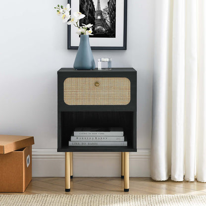 Black mid-century bedside table with woven cane drawer, open lower shelf, gold legs, topped by blue vase and white flowers.
