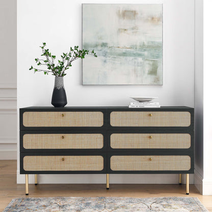 Charcoal 6-drawer dresser with cane-front drawers, gold legs and knobs, topped with a vase of greenery and books, abstract art above.