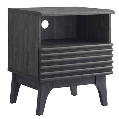 Black wood nightstand with open cubby, cable hole, ribbed drawer face, and tapered legs.