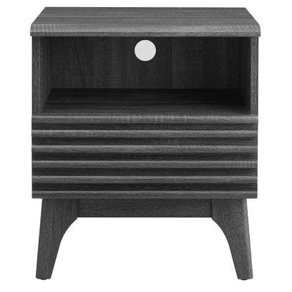 Black mid-century nightstand with open cubby, ribbed drawer front, circular cable hole, and tapered splayed legs.