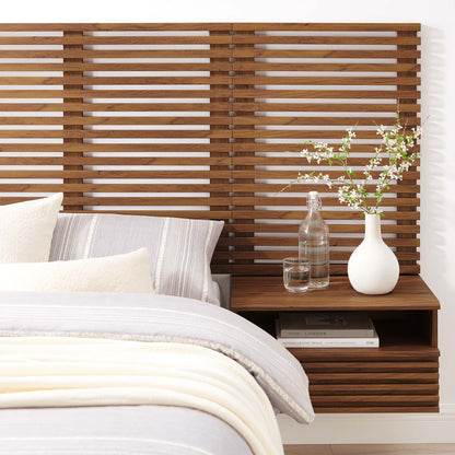 Walnut slatted wall-mounted twin headboard with floating nightstands, glass bottle, white vase with blossoms, cozy gray-cream bedding.