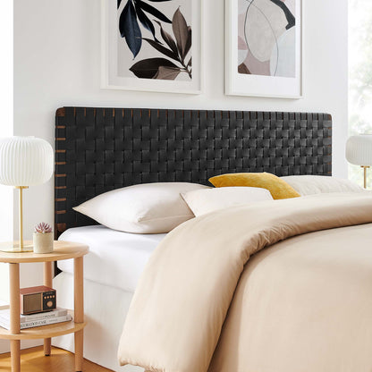 Woven dark headboard in walnut-black finish with beige duvet, white sheets, yellow throw pillow, and round wooden nightstands.
