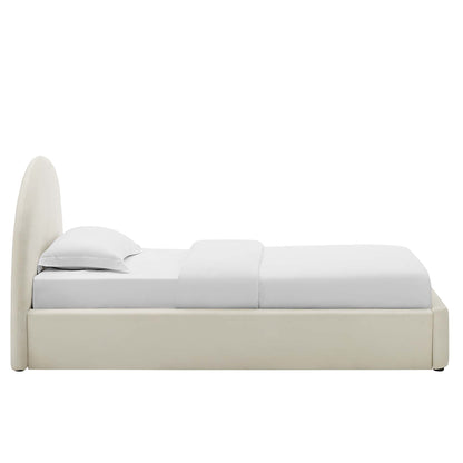 White velvet upholstered platform bed with an arched headboard and white bedding; contemporary minimalist design.
