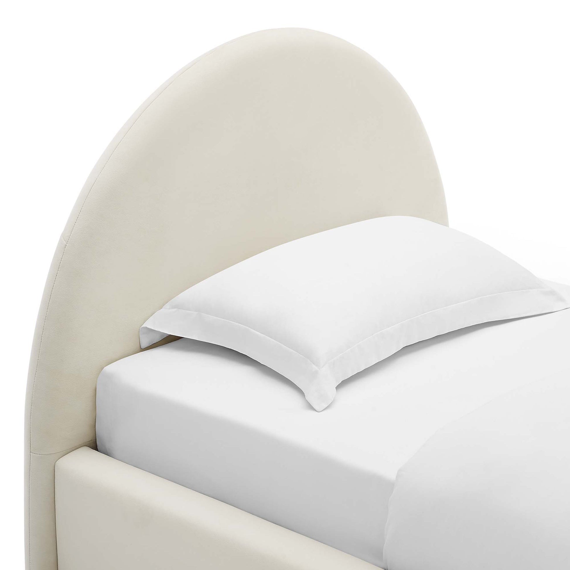 Cream curved upholstered headboard bed with white sheets and pillow