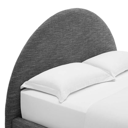 Charcoal gray curved fabric headboard with white pillows on a white bed.