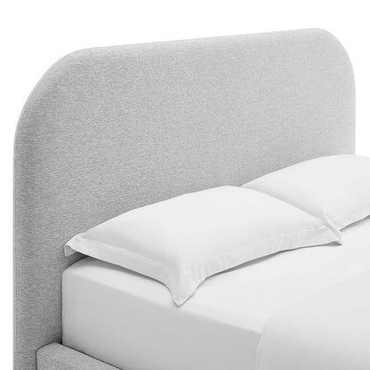Light gray curved upholstered fabric headboard and matching king bed frame with white sheets and two white pillows.