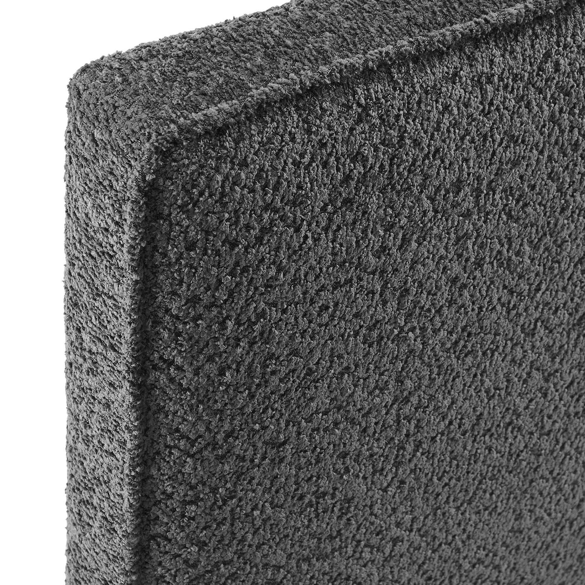 Charcoal gray boucle fabric close-up on a twin headboard; textured surface and edge.