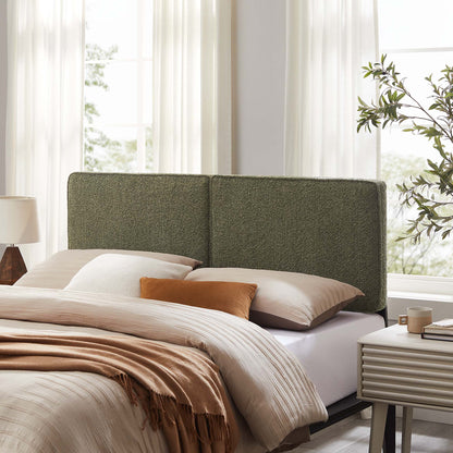 Olive-green boucle fabric full headboard; modern nightstand and plant by sunlit windows.