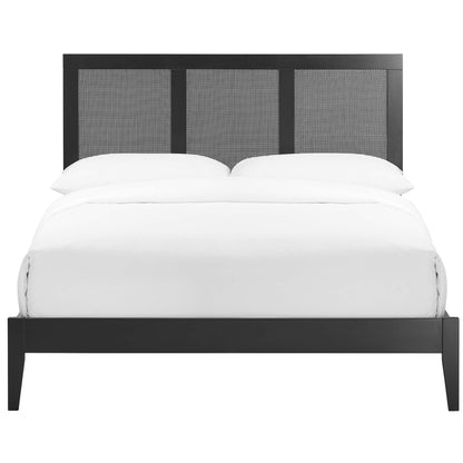 Black rattan and wood full platform bed with a three-panel woven headboard and white bedding.