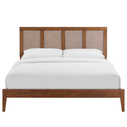 Walnut wood bed with a four-panel beige upholstered headboard and white bedding; clean mid-century modern design.