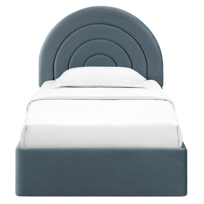 Blue-gray upholstered bed with a concentric arc headboard and white bedding.