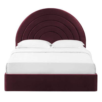 Burgundy velvet platform bed with concentric circular arc headboard and white bedding.