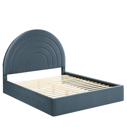 Blue velvet king platform bed with an arched, concentric headboard and slatted base.