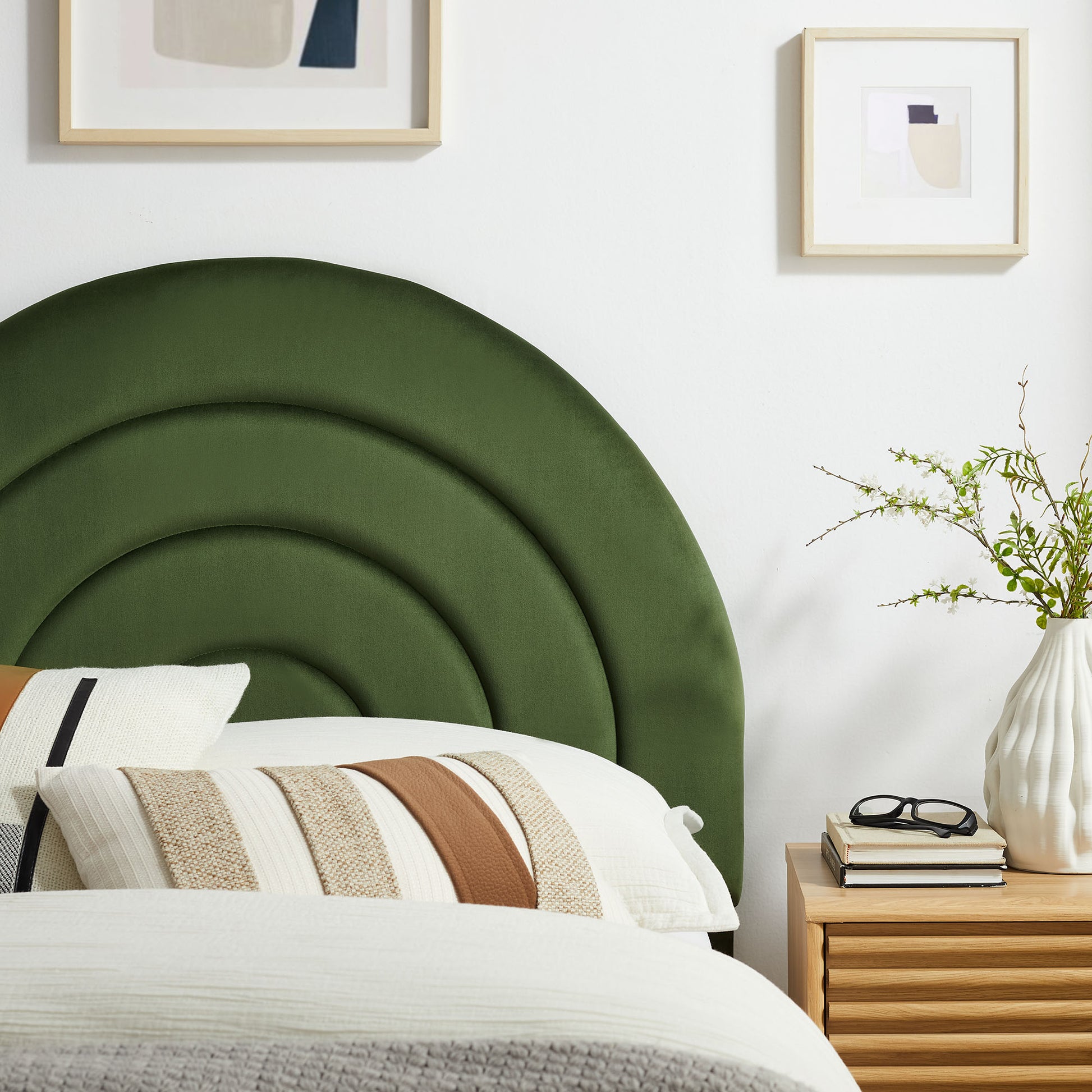 Green curved velvet twin headboard with white bedding.