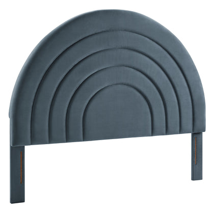 Blue velvet upholstered arched headboard with stacked curved panels and attached legs.