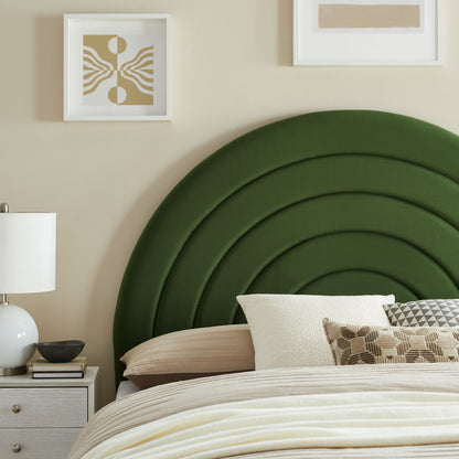 Bedroom with a bold green arched headboard, beige bedding, white pillows & a white nightstand with lamp.