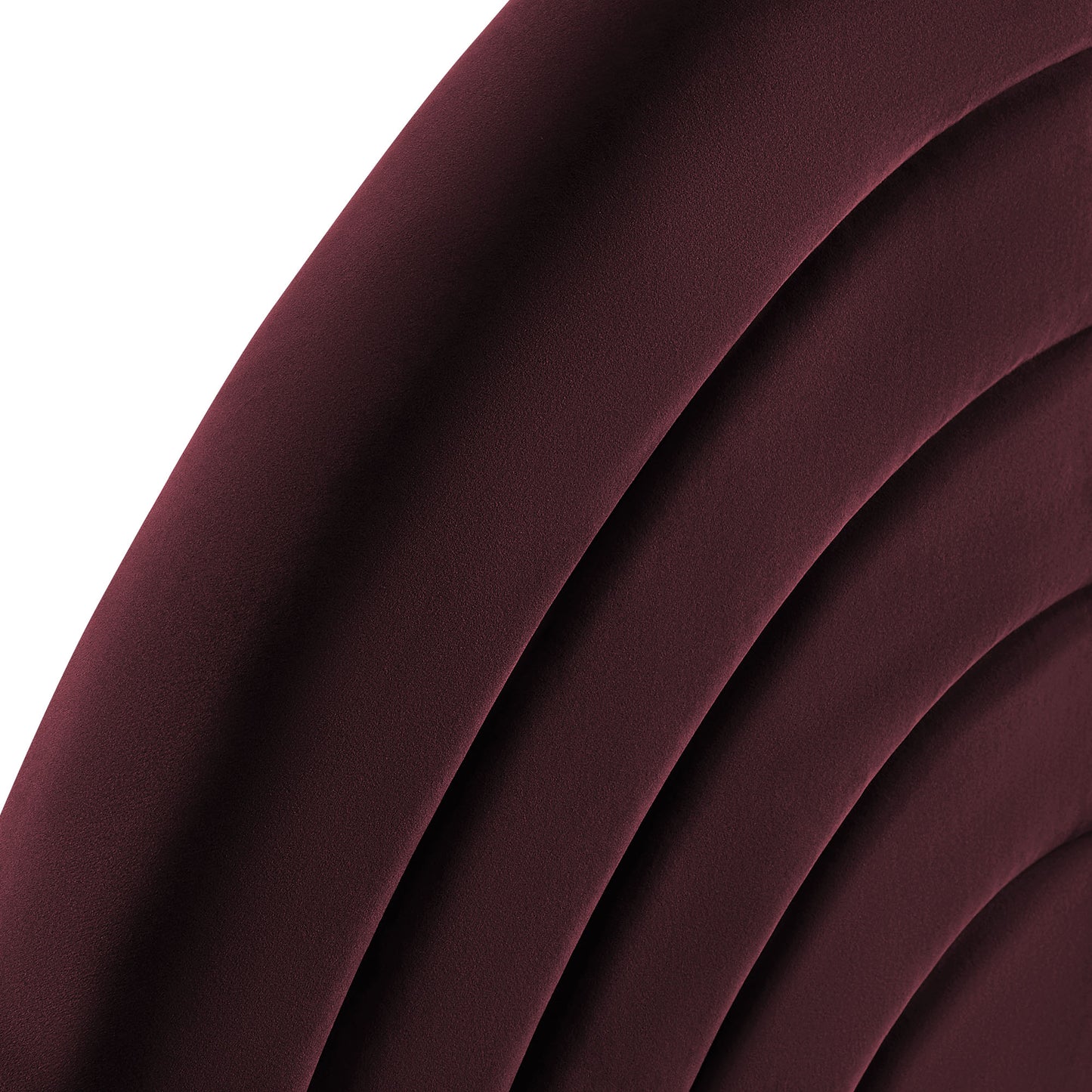 Burgundy velvet upholstered headboard with curved channel tufting and plush padded curves.