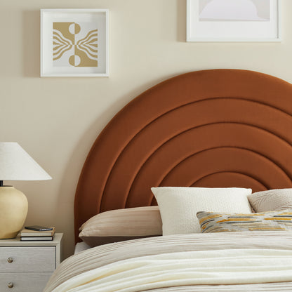Brown curved upholstered headboard with concentric arches, beige bedding, white pillows, and a beige nightstand with lamp.